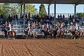 Junge Cowgirls und Cowboys reiten während des großen Einzugs bei einem Rodeo in einer ländlichen Kleinstadt in Utah an der Tribüne vorbei.