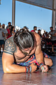 A fatigued athlete takes a moment to recover after a demanding CrossFit competition in Sevilla, España, showcasing strength and endurance.