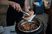 Traditional roasted pork sandwich at Festival of St John of Porto (Festa de São João do Porto ) during Midsummer, on the night of 23 June (Saint John's Eve), in the city of Porto, Portugal