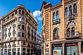 View of casa para Rafael Lora (left, 1930) and Casa Nogueira (right, 1907), modernist and neomudéjar buildings in Sevilla, Spain. Architectural landmarks by Ramón Cortázar, Juan Talavera y Heredia, and Aníbal González.