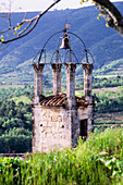 Alter Kirchenglockenturm in hügeliger Landschaft