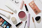 Draufsicht auf Beauty- und Make-up-Produkte vor weißem Hintergrund