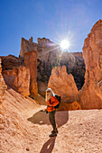 Porträt einer lächelnden Frau beim Wandern im Bryce Canyon National Park an einem sonnigen Tag