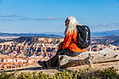 Ältere Frau mit Rucksack betrachtet die Aussicht im Bryce Canyon National Park