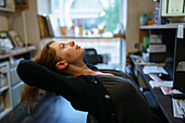 Woman leaning on chair in office