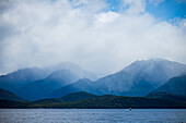 Fjord umgeben von wolkenverhangenen Bergen im Fiordland-Nationalpark