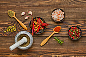 Selection of spices with mortar and pestle on wooden table