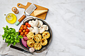 Ingredients for mushroom pasta: fettuccine, mushrooms, tomatoes, parmesan, basil