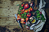 Assorted tomatoes and fresh herbs on a wooden board