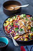 Raw vegetable salad with chicken, barley, mango and peanut dressing