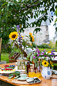 Summer garden table with bouquet of flowers and cake