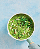 Pea and edamame soup garnished with almonds and chives