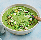 Pea and edamame soup garnished with almonds and chives