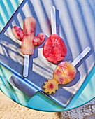 Fruity ice lollies in cactus, strawberry and pineapple shapes