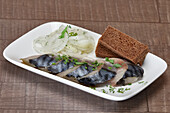 Pickled herring with onion rings and brown bread