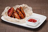 Deep-fried chicken wings with ketchup