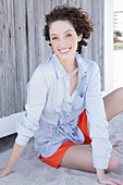 Young woman in light blue shirt dress and shorts