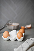 Fresh eggs in an egg carton, cracked egg