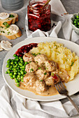 Swedish Köttbullar with peas, mashed potatoes and lingonberries