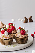 Cupcakes mit Himbeercreme, frischen Himbeeren und Schokoladenmandeln