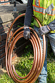 Worker replacing lead water pipes with copper
