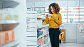 Woman looking at medication in pharmacy