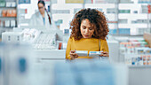 Woman looking at medication in pharmacy