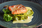 Fried salmon fillet with salad and cream sauce