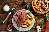 Grilled beef steak with herbs and potato wedges