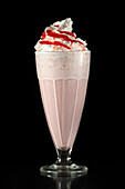 Strawberry milkshake with whipped cream and strawberry sauce