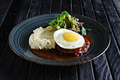 Beef meatball with fried egg and mashed potato