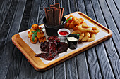 Snack platter with buffalo wings, onion rings and potato croquettes