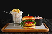 Juicy burger with cranberry sauce, cheese, rocket, chips and red cabbage salad