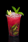 Blackberry mojito with lime slices and mint