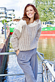 Rothaarige Frau in braun-beigem Strickpullover mit Lochmuster