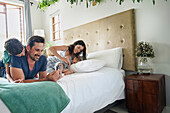 Parents with children relaxing on bed