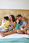 Parents with children relaxing on bed