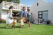 Parents with children playing in backyard