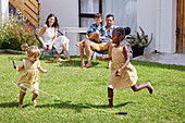 Parents with children playing in backyard