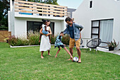 Parents with children playing in backyard