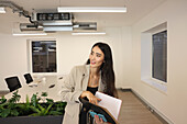 Smiling businesswoman holding files in conference room