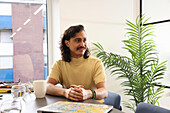 Smiling man sitting in creative office