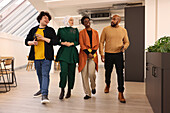 Smiling workers walking in modern office