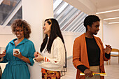 Smiling women talking in office