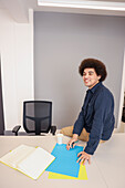 Employee sitting on desk in office