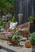 Boho style on a patio, magnificent candle, fragrant stonecrop, elfin spurge 'Pink Panther' in a newspaper stand, yarrow, silver rain, spurge 'Athene' in a hanging basket