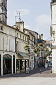 Historische Altstadt von Cognac mit Einkaufsläden und blühendem Balkonschmuck