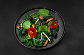 Kale salad with blackberries, nasturtium and pecans