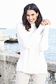 Long-haired young woman in white turtleneck jumper, laughing, red lipstick