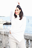 Long-haired young woman in white turtleneck jumper, laughing, red lipstick